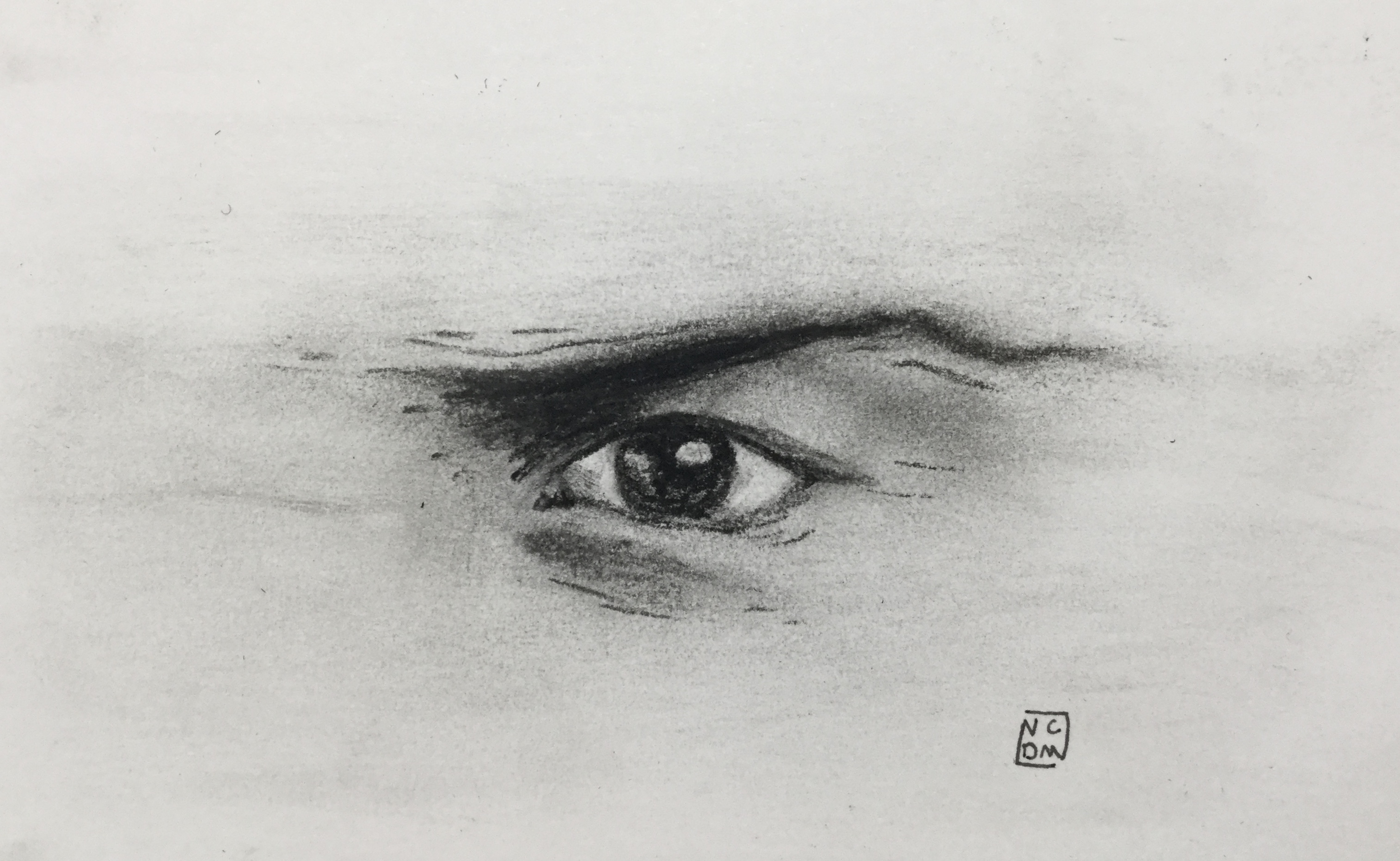 Small charcoal drawing of an eye that seems frustrated